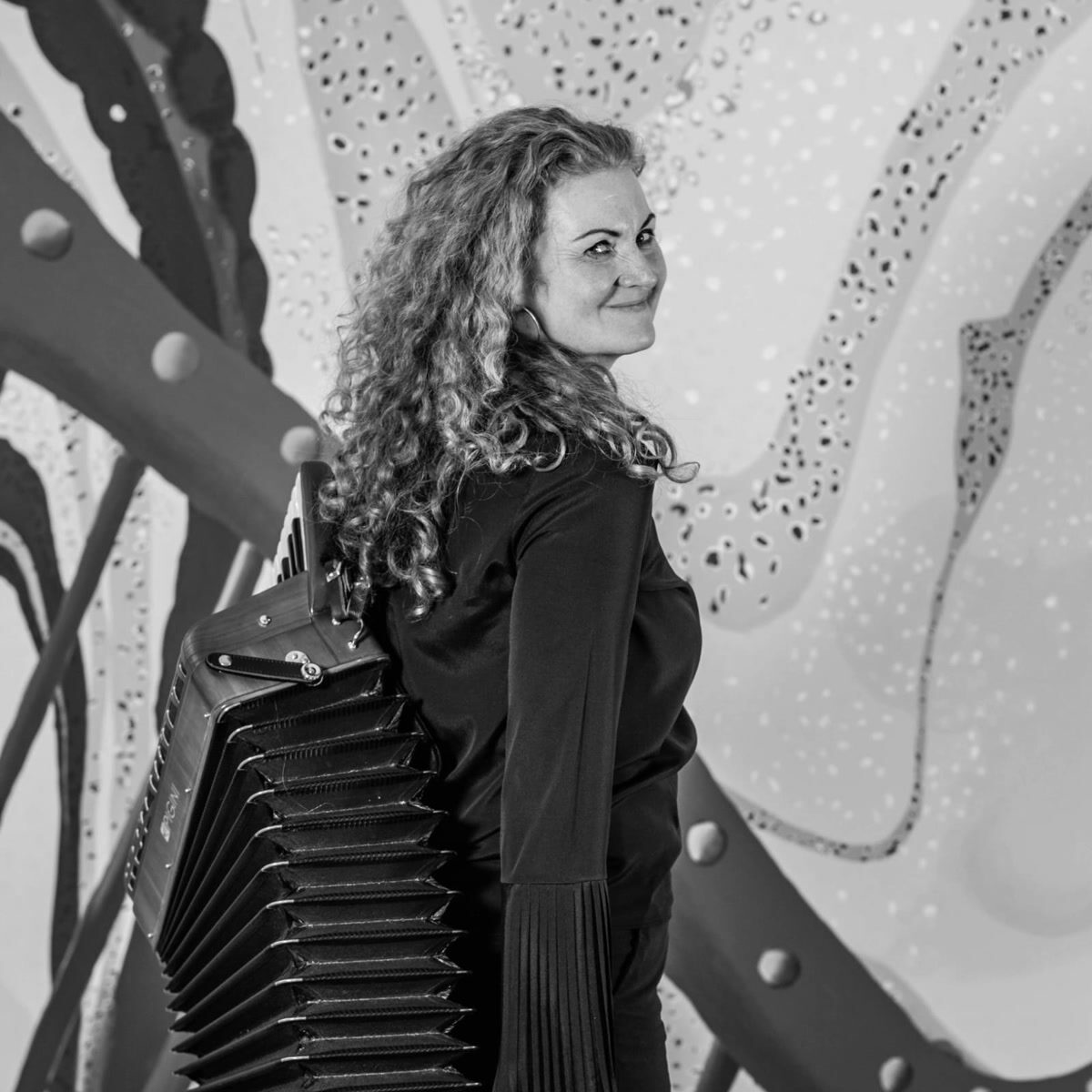 Portraitfotografie – Frau mit Akkordeon vor künstlerischem Hintergrund